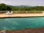 Piscine sur sa grande terrasse en béton coloré face à la montagne Sainte Baume, au milieu des Vignes